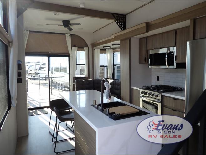Forest River RV Salem Grand Villa 42VERANDA destination trailer interior with kitchen island, stove, and seating.